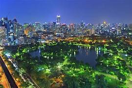 Park in Bangkok with trees and water and buildings in the background